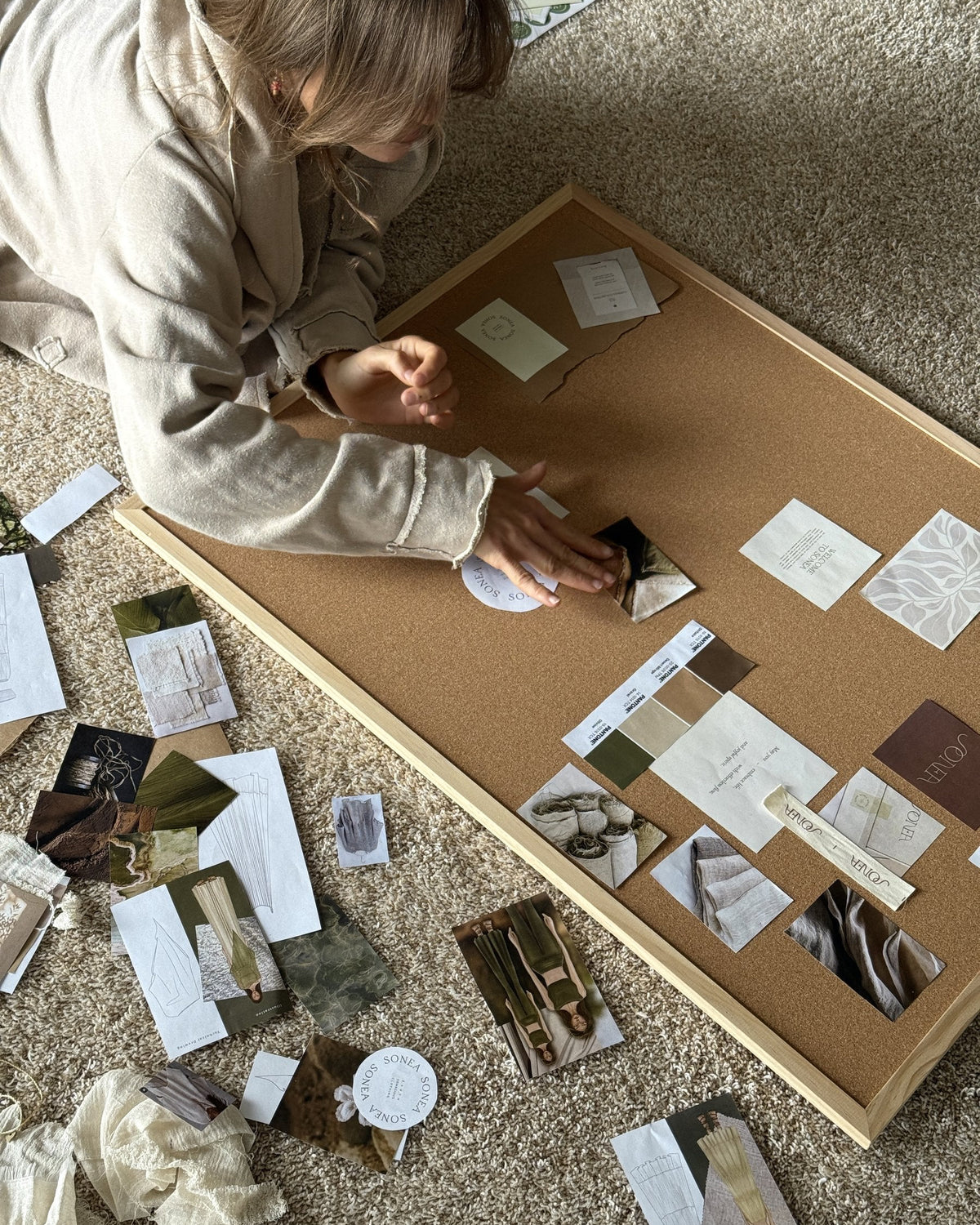 Jamy arranging the SONEA mood board on the floor of her home studio