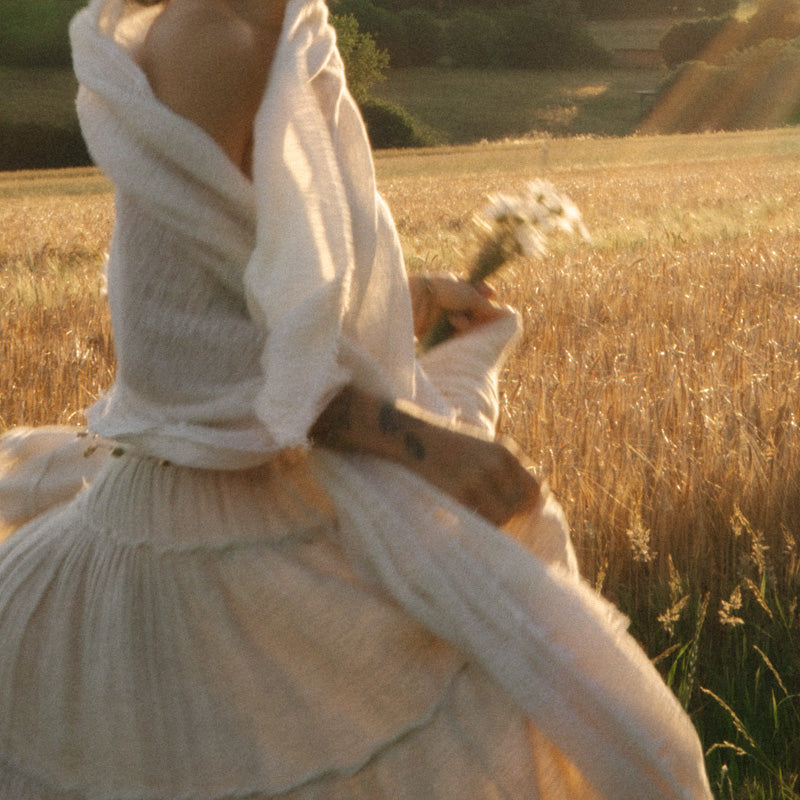 Two women in undyed SONEA pieces, dress and shawl, in a summer field